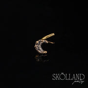 A real 14K yellow gold crescent moon nose stud on a black background, featuring a sparkling design.