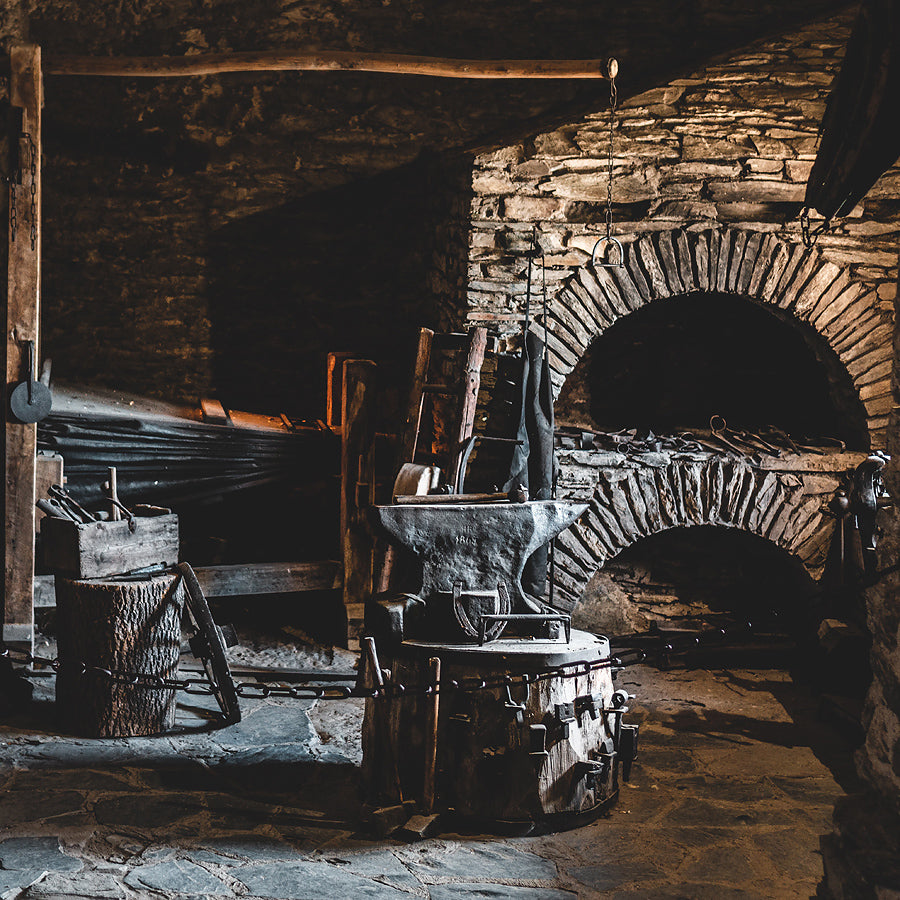View of a historic blacksmith shop, featuring an anvil, forge, and other tools of the trade