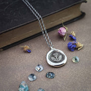 Modern heirloom with vintage styling. handmade thistle pendant surrounded by decorative gems and dried flowers