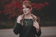 A woman in a green dress is wearing the mother necklace, a symbolic pieces of celtic jewelry inspired by womanhood.