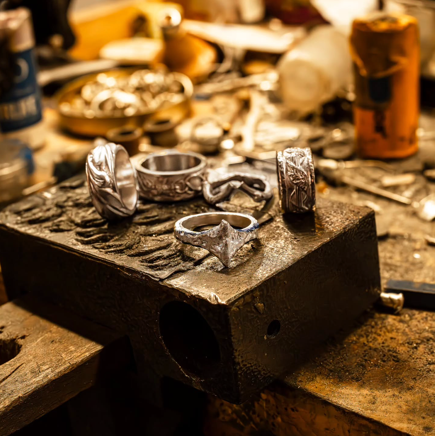 Close-up of silver rings with intricate designs, conveying a craftsmanship theme. Text reads, "Handmade vs. Mass-Produced Jewelry: Buyer's Guide."