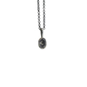 Silver necklace with a small bezel pendant that features a moon with a faceted clear quartz set on top