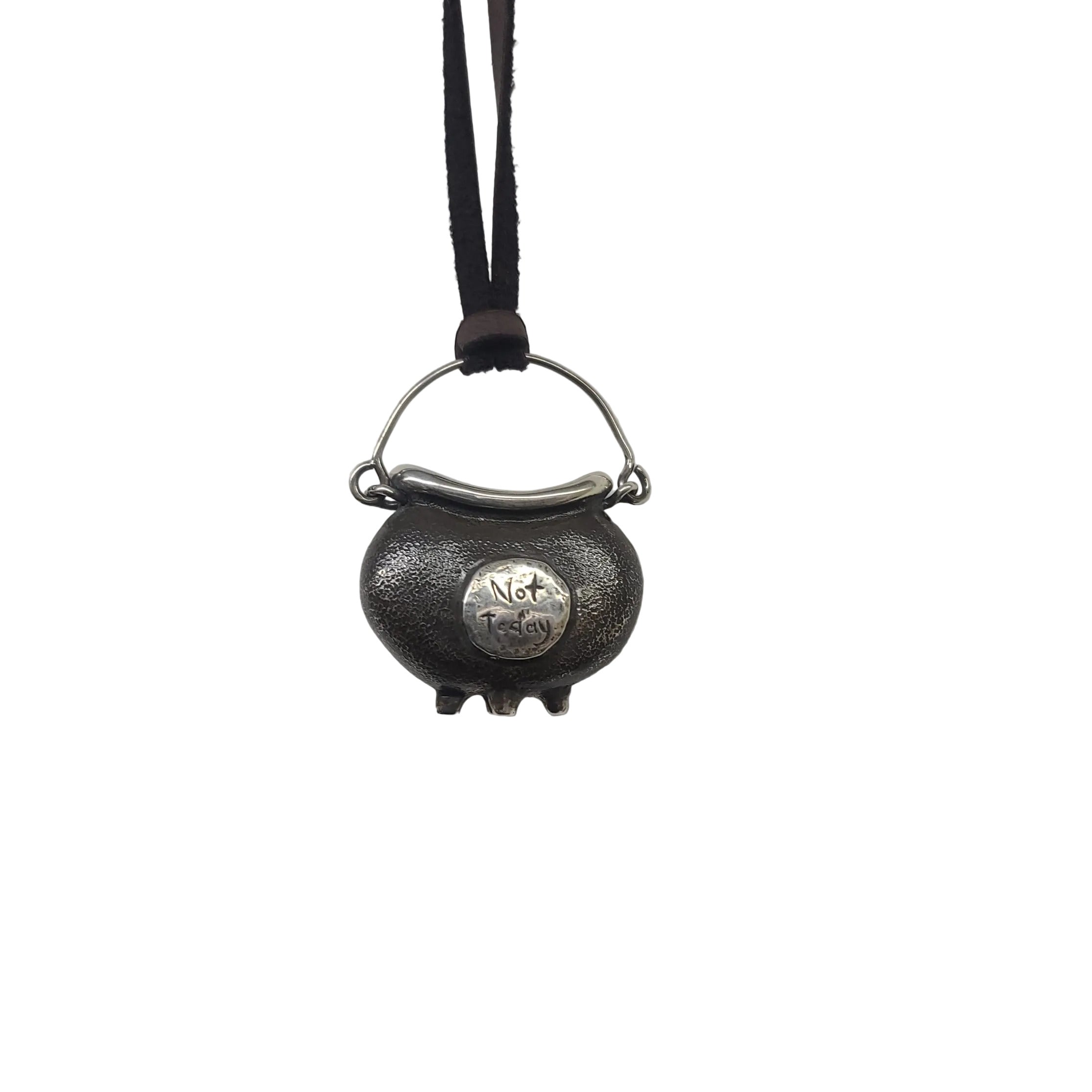 A small cauldron made from sterling silver. It features the words "not today" on the front, and is hung from a brown leather cord