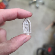 Hand holding the unfinished form of this pendant right after it was cast in its natural silver state. The pendant features 3 stars,crescent moon, and a gothic style sculpted border. 