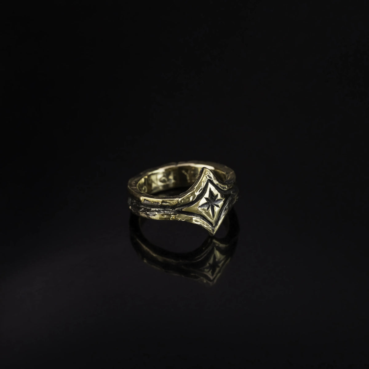 10K yellow Gold ring with a focal center star on a black background