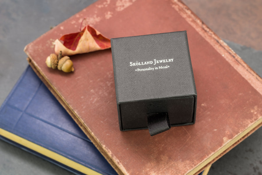 Black branded jewelry box that reads " Skolland Jewelry- Personality in metal" 
