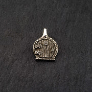 angled photo of a sterling silver fairy door charm