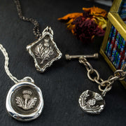 a selection of 3 different handmade thistle necklaces and charms by Skolland Jewelry